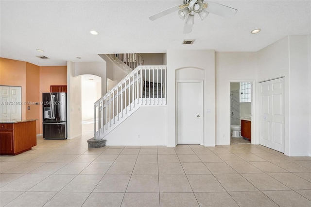 unfurnished living room with light tile patterned floors and ceiling fan