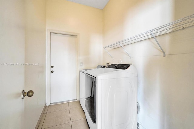 laundry area with light tile patterned floors and independent washer and dryer