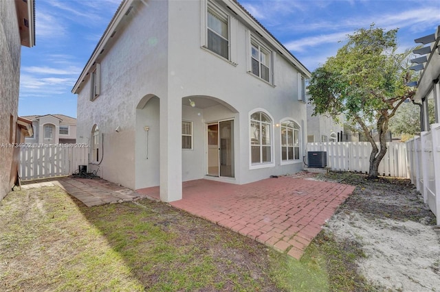 back of property with cooling unit and a patio