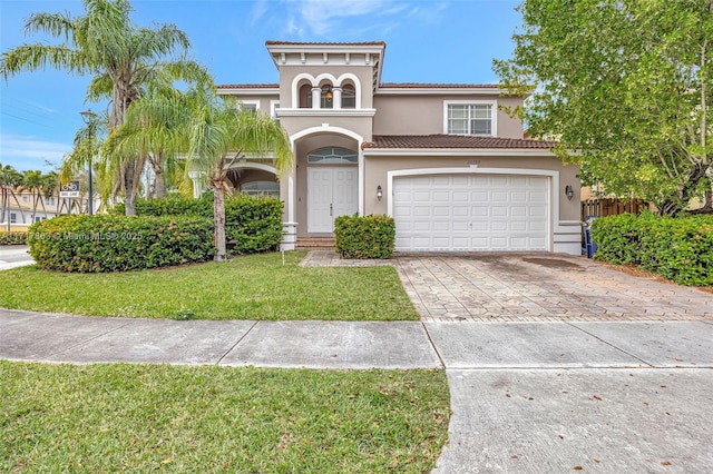 mediterranean / spanish-style house featuring a garage and a front yard