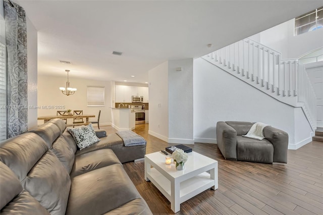 living room with an inviting chandelier and hardwood / wood-style floors