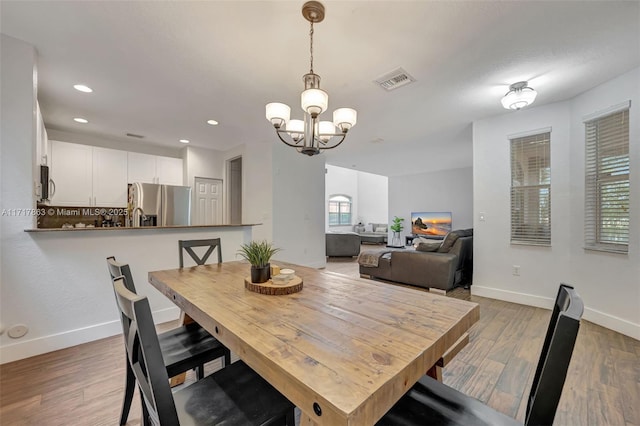 dining room featuring hardwood / wood-style flooring and a notable chandelier