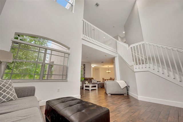 living room featuring hardwood / wood-style floors, a high ceiling, and a notable chandelier