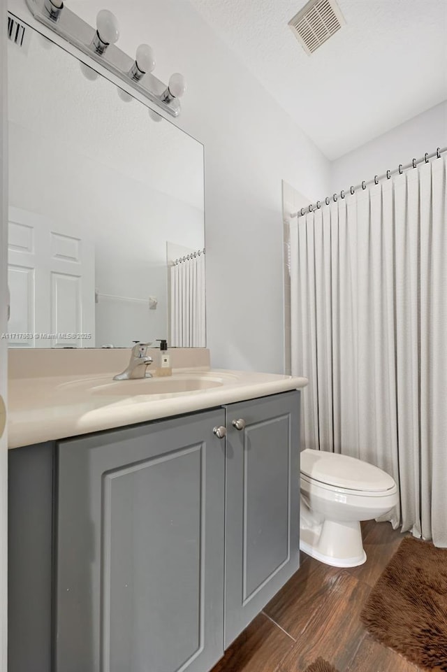 bathroom with vanity, hardwood / wood-style floors, and toilet