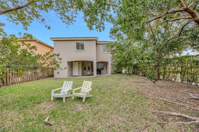 back of property with a patio area and a lawn