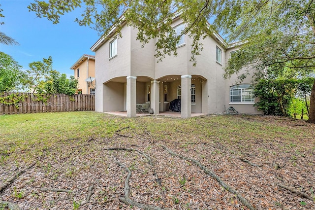 back of property featuring a patio and a lawn