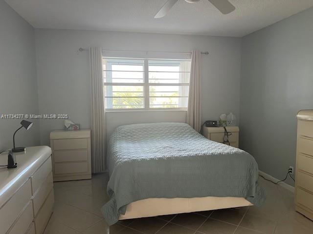 bedroom with ceiling fan and light tile patterned flooring