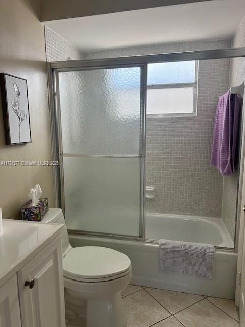 full bathroom with tile patterned floors, toilet, combined bath / shower with glass door, and vanity