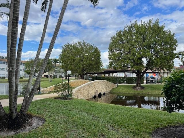 view of community with a lawn and a water view