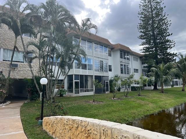 view of property's community with a yard and a water view