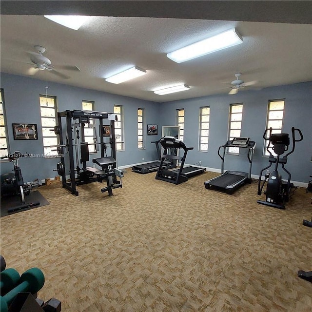 workout area with ceiling fan, carpet flooring, and a textured ceiling