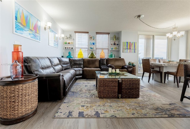 living room featuring a chandelier, hardwood / wood-style floors, and a textured ceiling