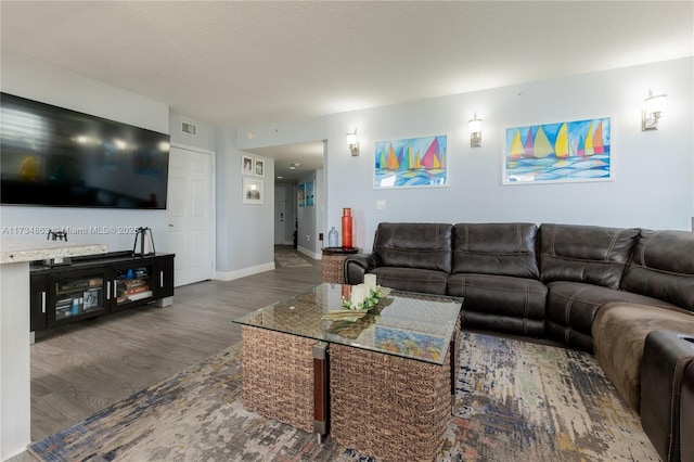 living room with dark wood-type flooring and a textured ceiling