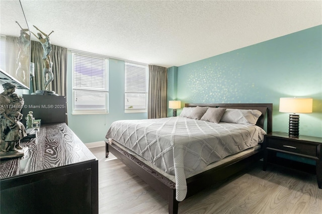 bedroom with hardwood / wood-style floors and a textured ceiling