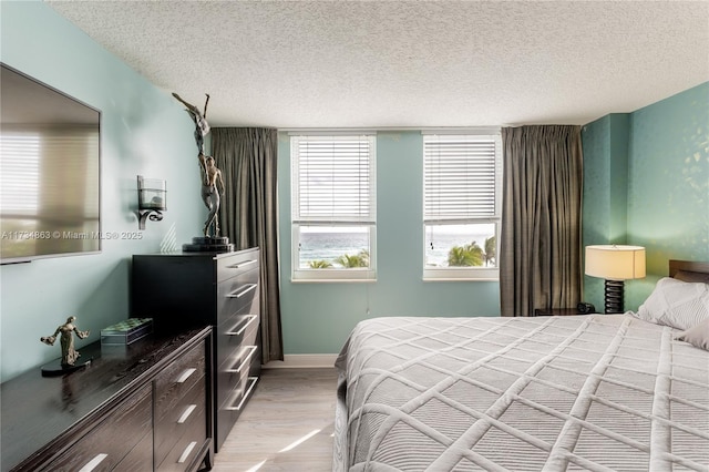 bedroom featuring light hardwood / wood-style flooring and a textured ceiling