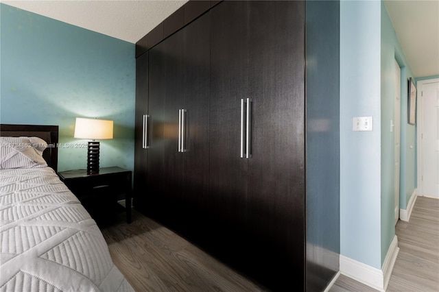 bedroom featuring paneled built in fridge and light hardwood / wood-style floors