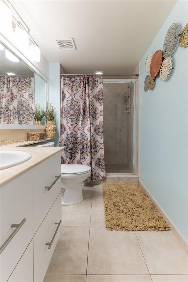 bathroom with tile patterned flooring, vanity, tiled shower, and toilet