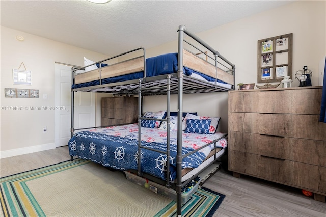 bedroom featuring hardwood / wood-style floors and a textured ceiling