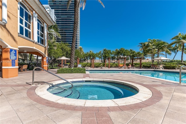 view of swimming pool with a hot tub and a patio