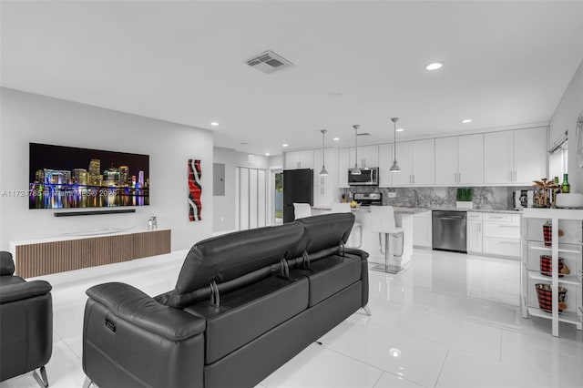 tiled living room with sink and electric panel