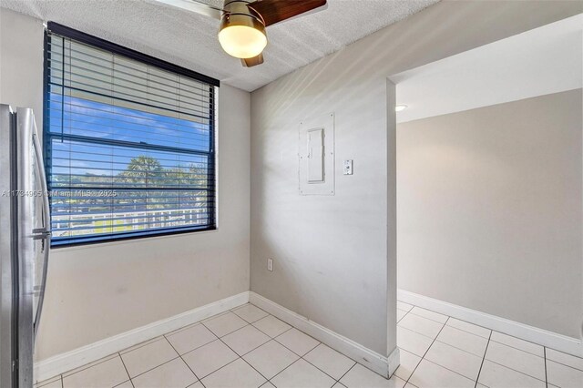 unfurnished room featuring light tile patterned floors, electric panel, and a textured ceiling