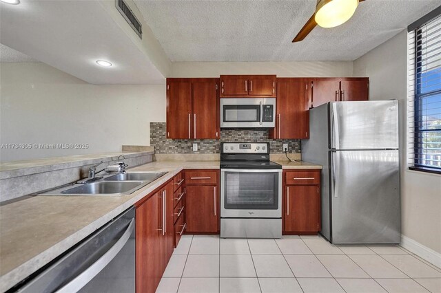 kitchen with stainless steel appliances, light tile patterned flooring, sink, and decorative backsplash