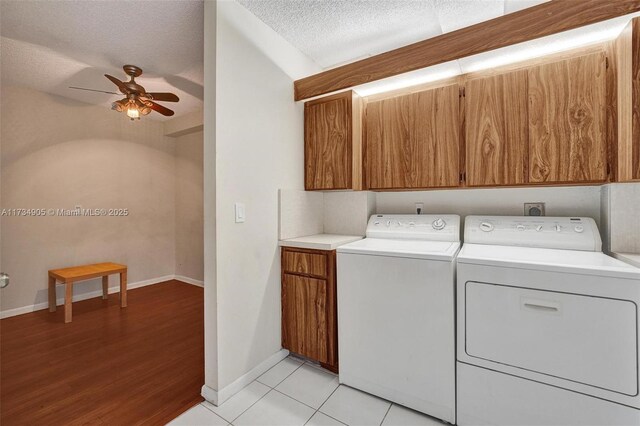 clothes washing area featuring cabinets, a textured ceiling, light tile patterned floors, ceiling fan, and independent washer and dryer