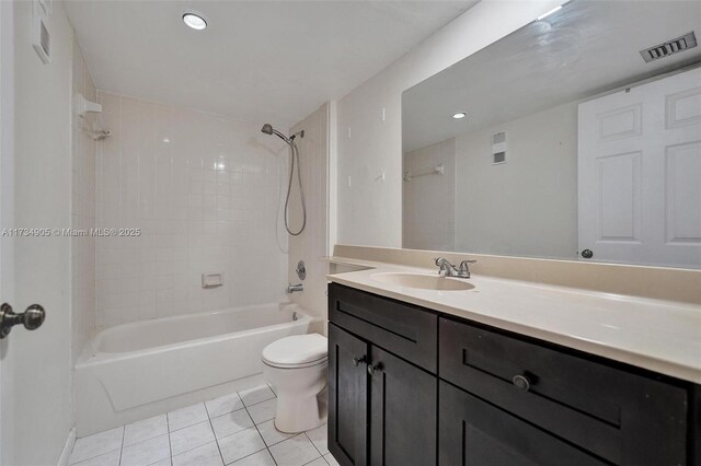 full bathroom with vanity, tiled shower / bath combo, tile patterned floors, and toilet