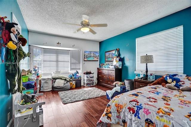 bedroom with ceiling fan, hardwood / wood-style floors, and a textured ceiling