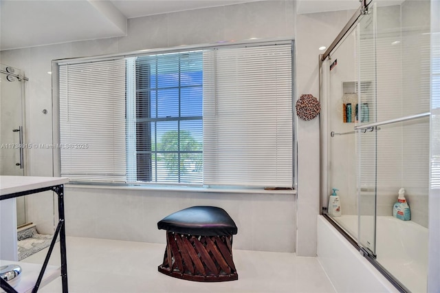 bathroom with bath / shower combo with glass door