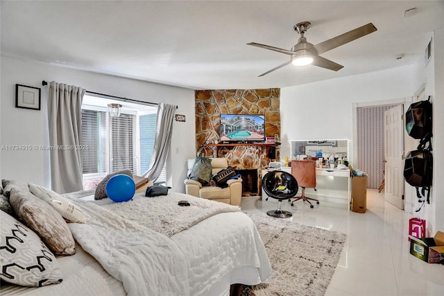 tiled bedroom with a stone fireplace and ceiling fan