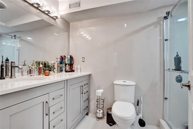 bathroom featuring vanity, a shower with shower door, and toilet