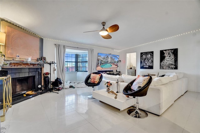 living room featuring tile patterned flooring, a tile fireplace, and ceiling fan