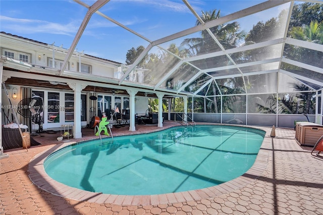 view of swimming pool with a patio, a lanai, and ceiling fan