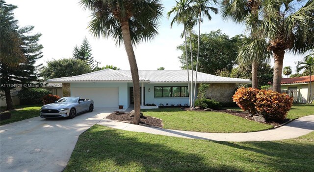 single story home featuring a garage and a front lawn