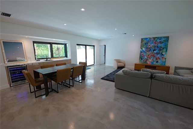 living room with concrete flooring, sink, and wine cooler