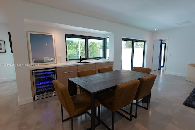 dining area with sink, beverage cooler, and concrete floors