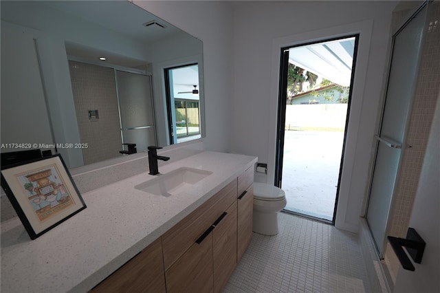 bathroom with vanity, tile patterned flooring, a shower with door, and toilet