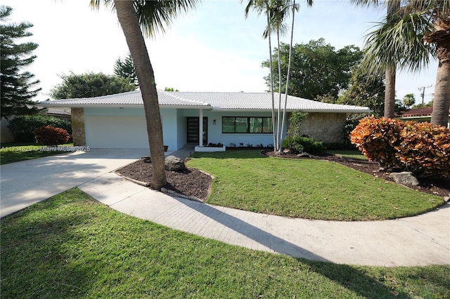 ranch-style house featuring a garage and a front lawn