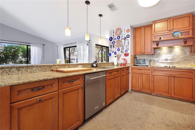 kitchen featuring sink, a wealth of natural light, light stone countertops, and hanging light fixtures