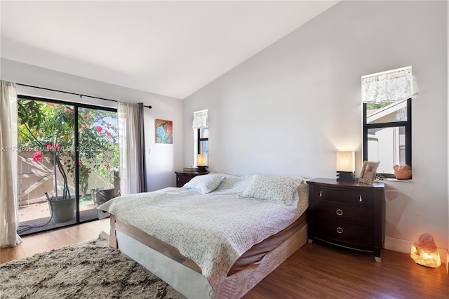 bedroom featuring hardwood / wood-style flooring, lofted ceiling, and access to exterior