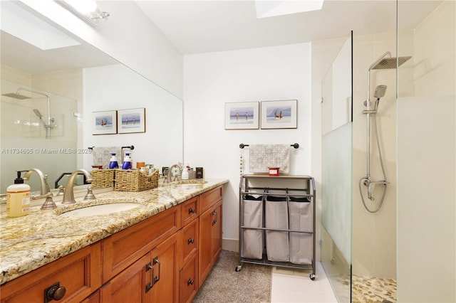 bathroom featuring vanity, a skylight, and a shower with door