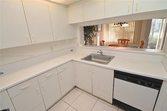 kitchen featuring white dishwasher, sink, white cabinetry, and light tile patterned floors