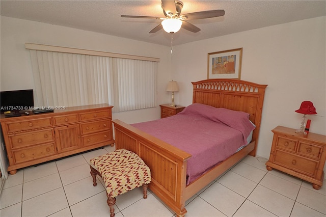 tiled bedroom with ceiling fan and a textured ceiling