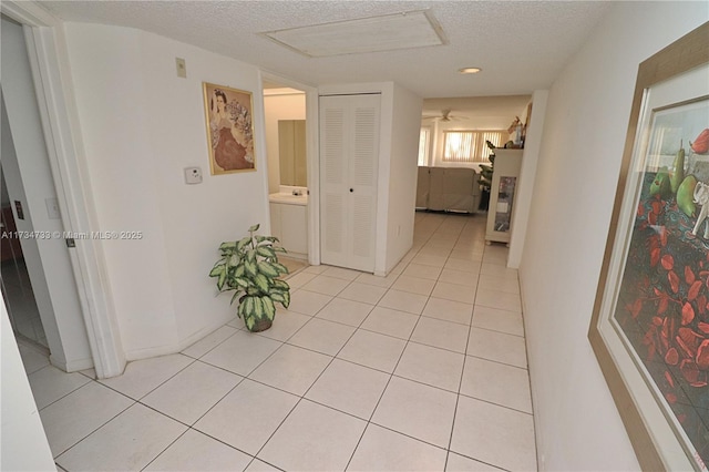 hallway with light tile patterned floors and a textured ceiling