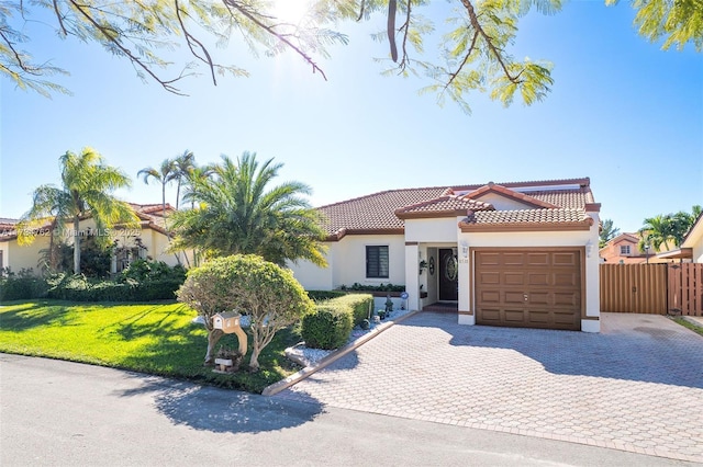 mediterranean / spanish house with a garage and a front lawn