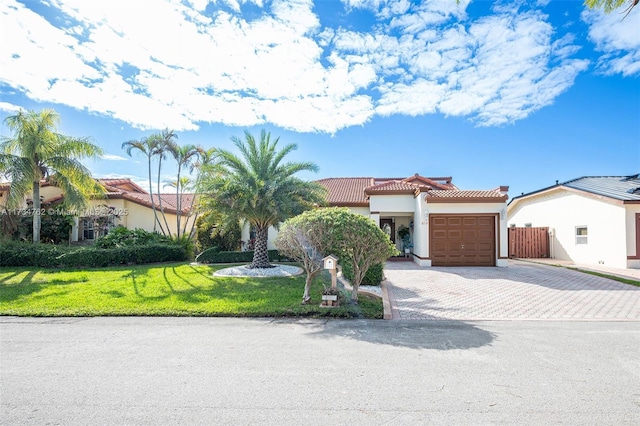 mediterranean / spanish-style house with a garage and a front yard