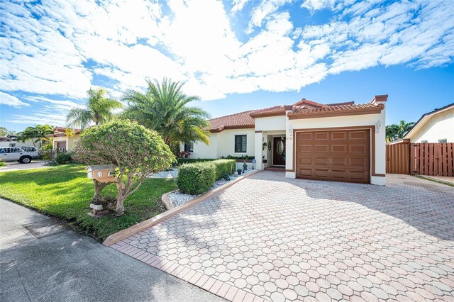 mediterranean / spanish house with a garage and a front lawn