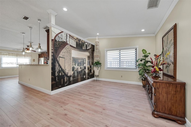 interior space featuring ornamental molding, ceiling fan, and light hardwood / wood-style flooring