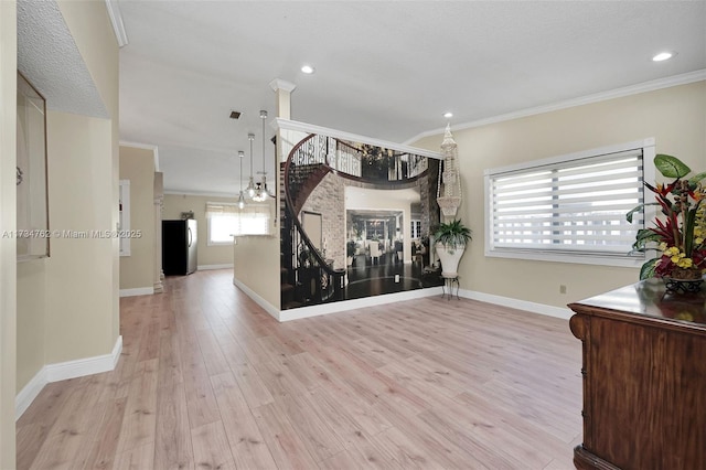 interior space featuring ornamental molding and light hardwood / wood-style floors